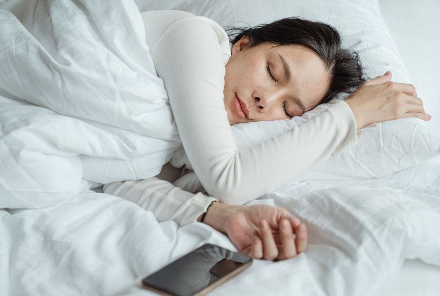 Woman-sleeping-in-bed-near-smartphone