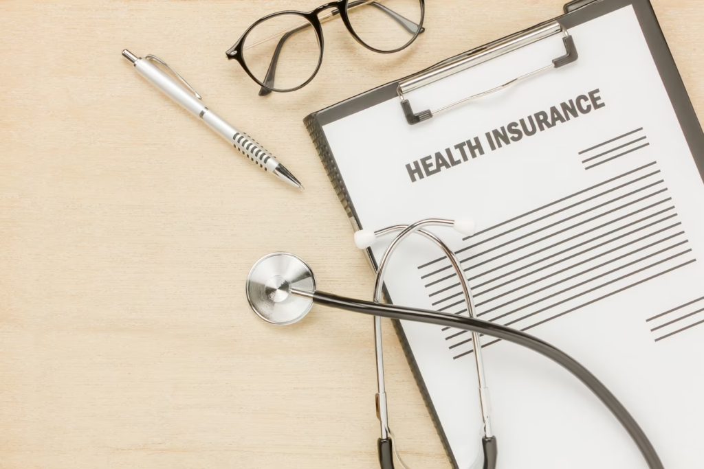 Top view health insurance form and eyeglasses with stethoscope on wooden background